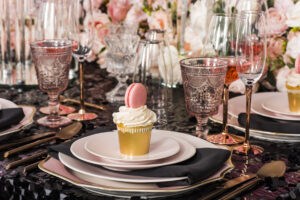 Glam night display table with pink cupcakes and plates