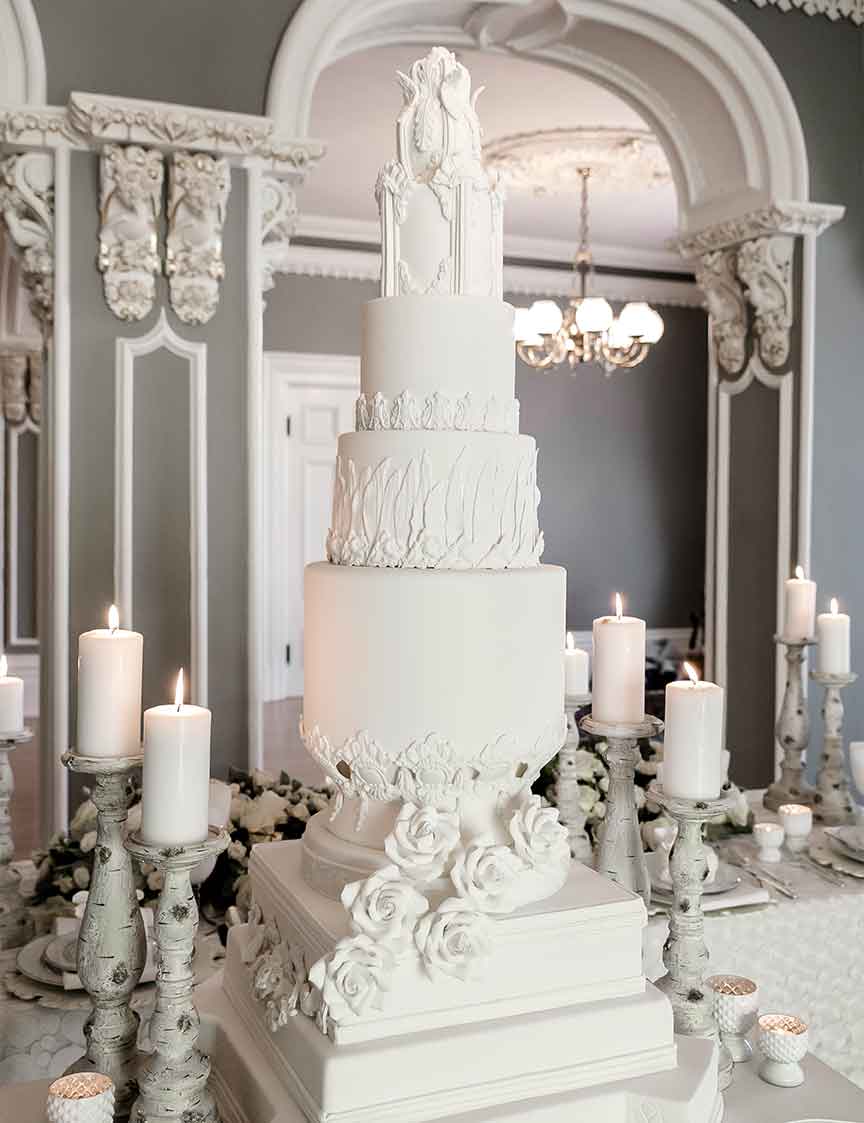 wedding cake all white with flowers, candles on the side