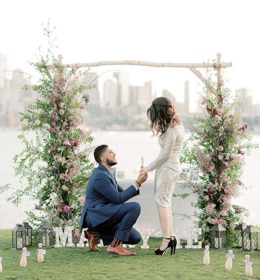 outdoor proposal with floral backdrop, bowling pins and lanterns